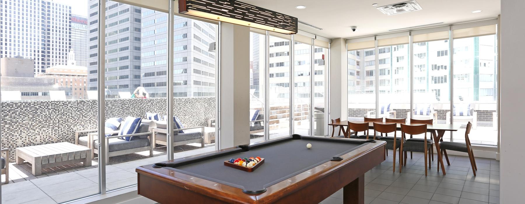 a pool table in a room with large windows