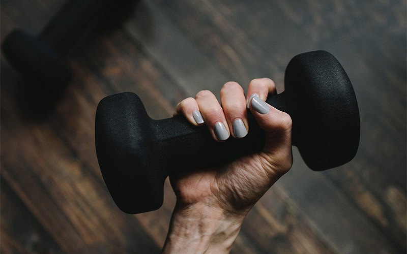 a person's hand holding a dumbbell